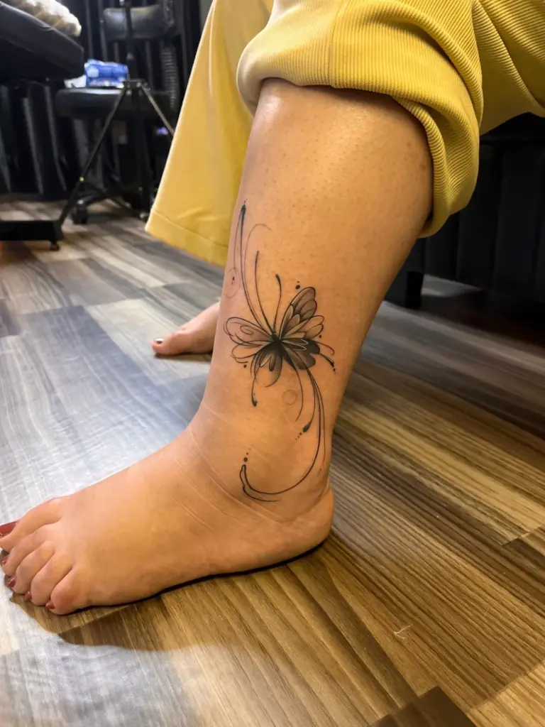 Black and grey fine-line butterfly tattoo on the ankle, Rays Tattoo Studio Kandivali