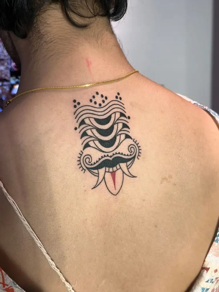 Ornamental black and red blackwork tattoo on the upper back, Rays Tattoo Studio