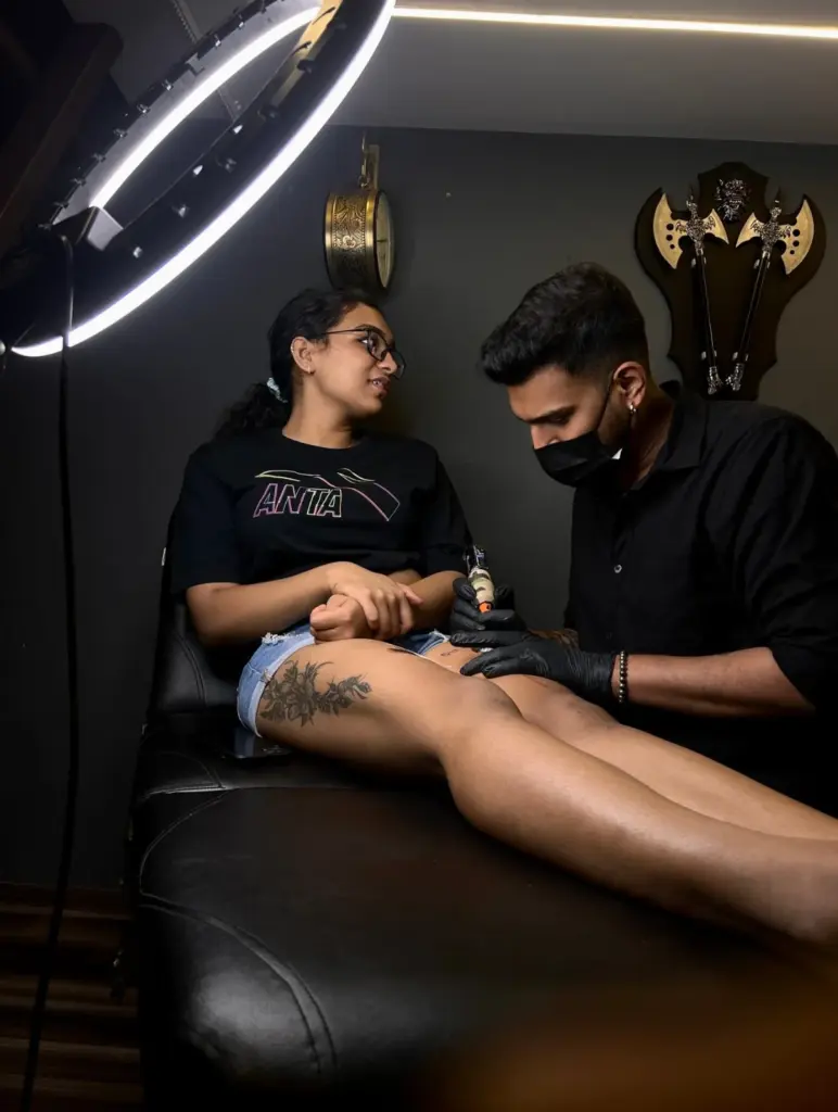 Tattoo artist working on a client's thigh tattoo at Rays Tattoo Studio, Kandivali East