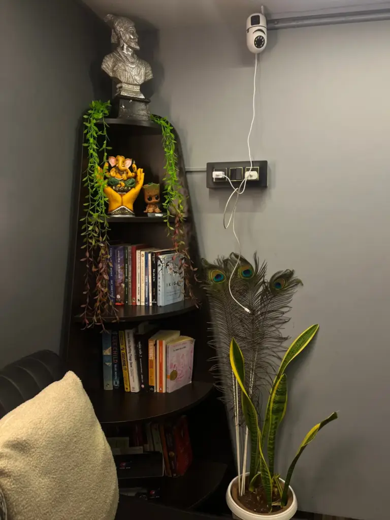 Studio corner with a Ganesha idol, Shivaji Maharaj bust, books and plants at Rays Tattoo Studio